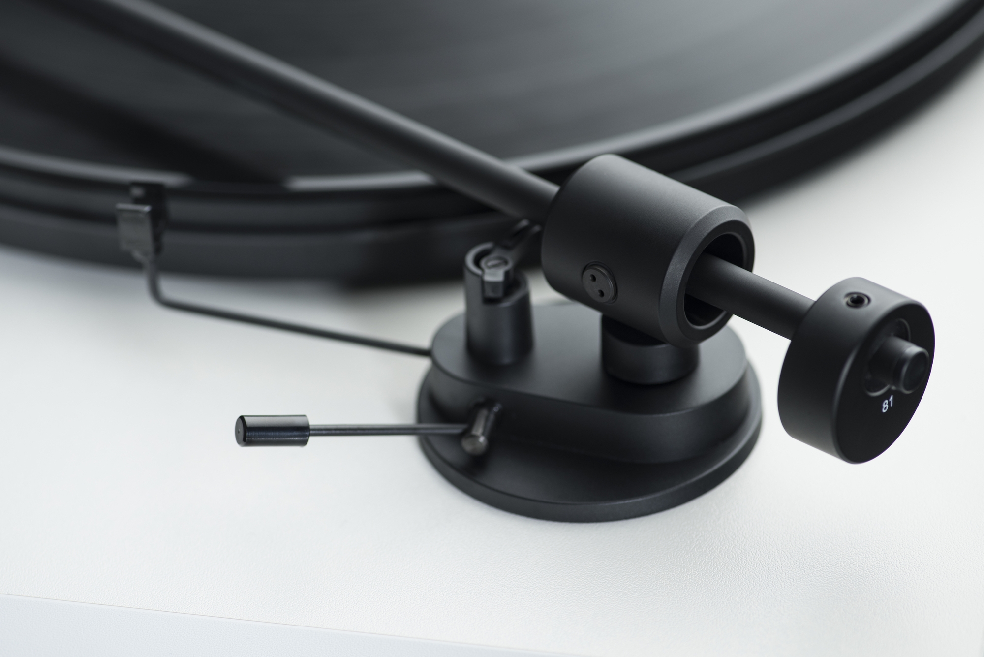 Pro-Ject Primary E Turntable With Om Cartridge Close-up of a black turntable tonearm and base.