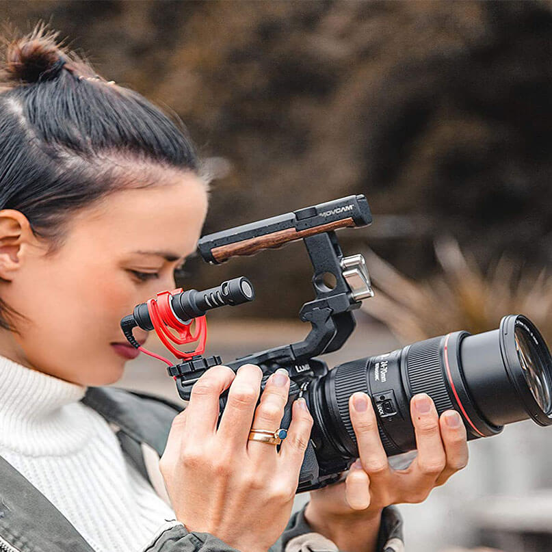 Rode Videomicro Movcam professional cinema camera rig with wooden top handle, external microphone, and large zoom lens.