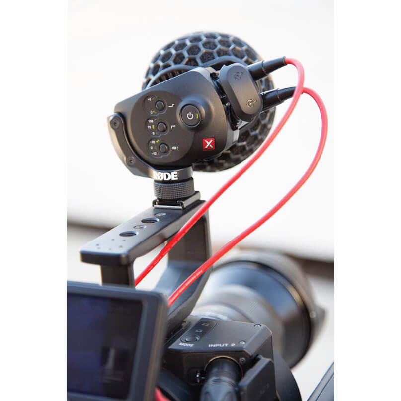 Rode Stereo Videomic X Rode microphone with hex mesh head mounted on a camera rig with red cable
