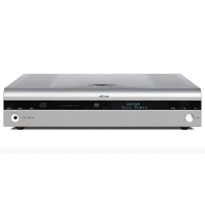 A silver ARCAM Solo Music Music System with a digital display, control buttons, and a central disc slot, viewed from the front.