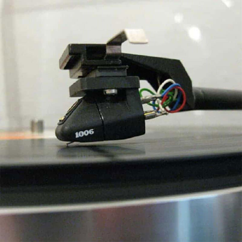 Goldring 1006 Moving Magnet Cartridge Phono turntable cartridge with stylus and multicolored wires, model 1006, mounted on a tonearm.