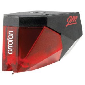 Interdyn An ortofon 2m red moving magnet cartridge in red and black, shown at an angle highlighting the stylus tip and the ortofon brand name on the side.