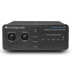 Cambridge Audio DacMagic 100 digital-to-analog converter with standby and source knobs and LED indicators on a brushed front panel.