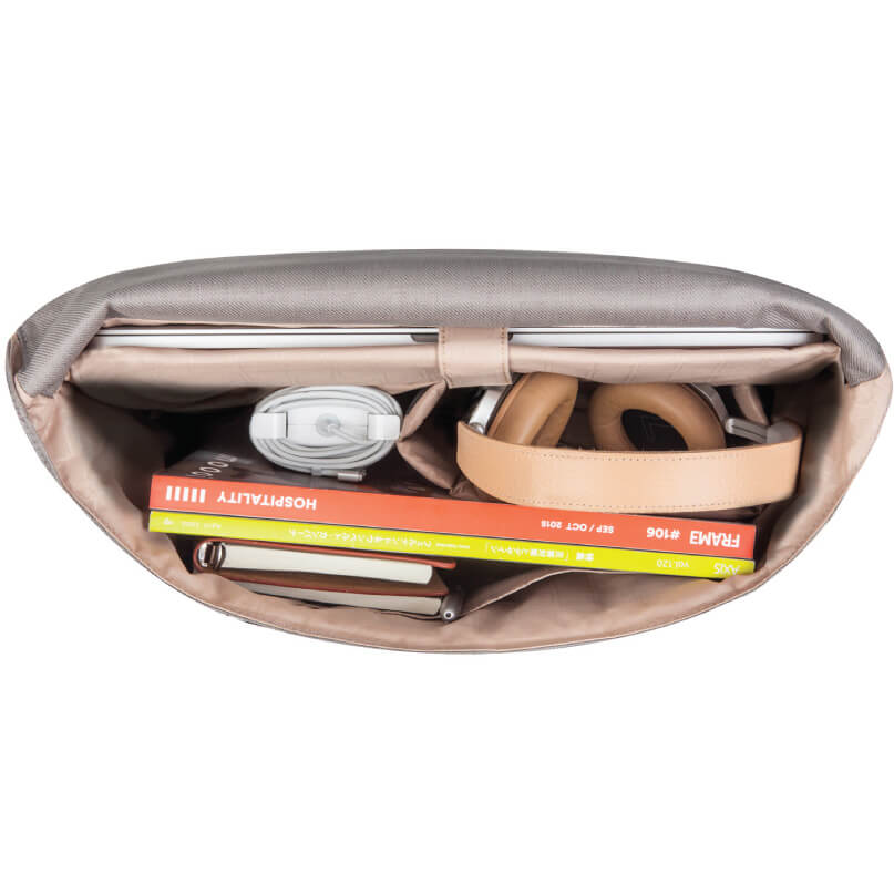 Moshi Aerio Messenger Bag 15&Quot; Beige fabric organizer bag opened to reveal magazines, a tan belt, white coiled cable, and small notebooks.