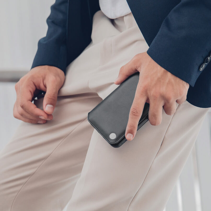 Moshi Overture For Iphone Xr Gray leather flip-style phone case with magnetic snap, held by a person in beige pants and navy blazer.