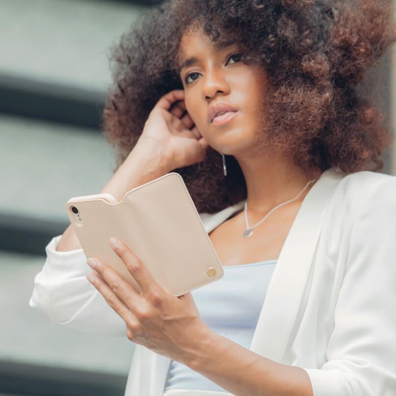 Moshi Overture For Iphone Xr Woman with curly hair holding a beige wallet-style phone case.