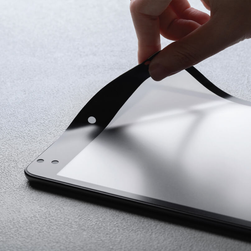 Moshi Ivisor Ag For Ipad Mini 5 - Black Person peeling a clear screen protector from a tablet, exposing a glossy touchscreen and front camera holes.