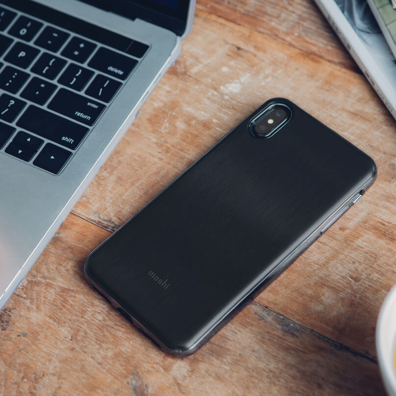 Moshi Iglaze For Iphone Xs Max Black smartphone with vertical dual-camera on back placed on a wooden desk beside a laptop.