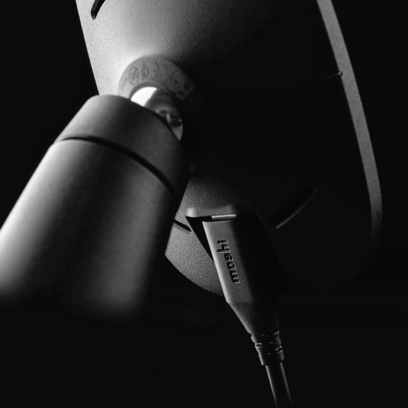 Moshi Snapto Magnetic Car Mount With Wireless Charging Close-up of a black microphone with a cable plug on a stand in low light.