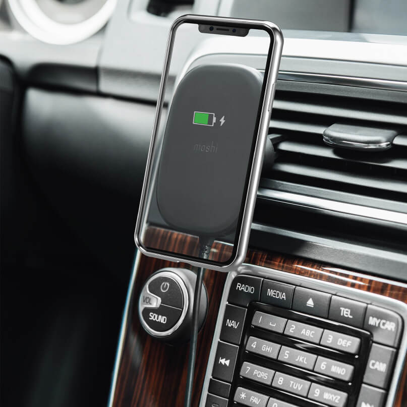 Moshi Snapto Magnetic Car Mount With Wireless Charging Moshi wireless car charger pad mounted on a car dashboard holding a smartphone.