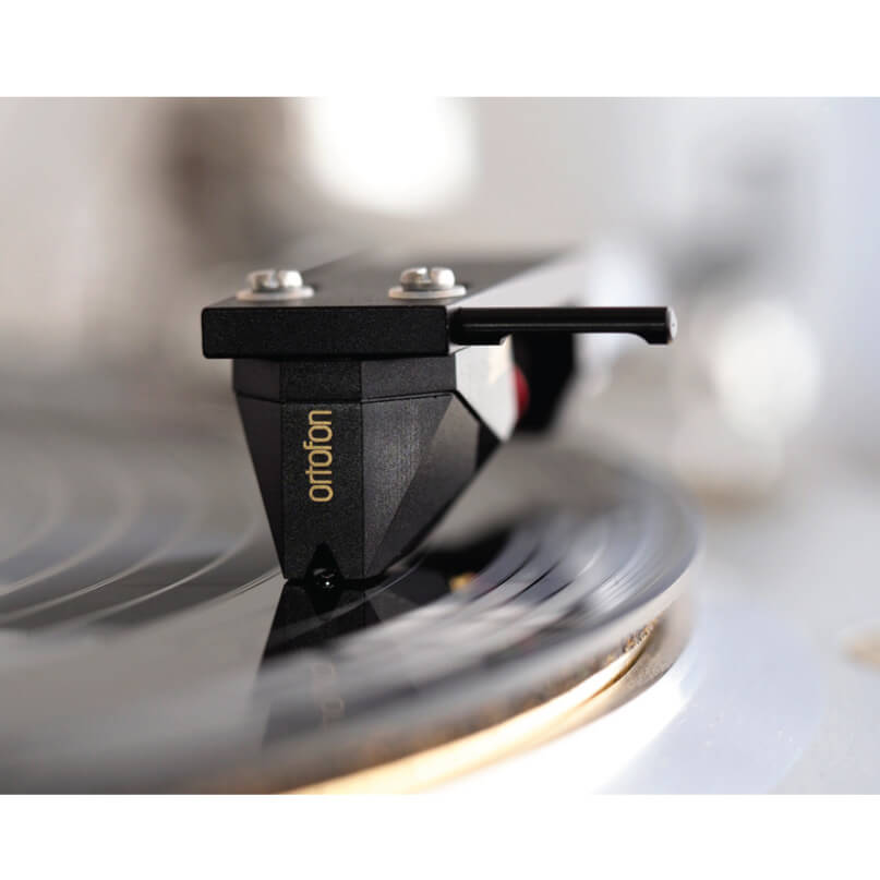 Ortofon 2M Black Moving Magnet Cartridge Ortofon phono cartridge mounted on a turntable tonearm over a spinning vinyl record