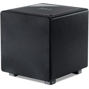REL subwoofer cube with black fabric grille, top panel displaying REL logo, low-profile compact speaker enclosure.