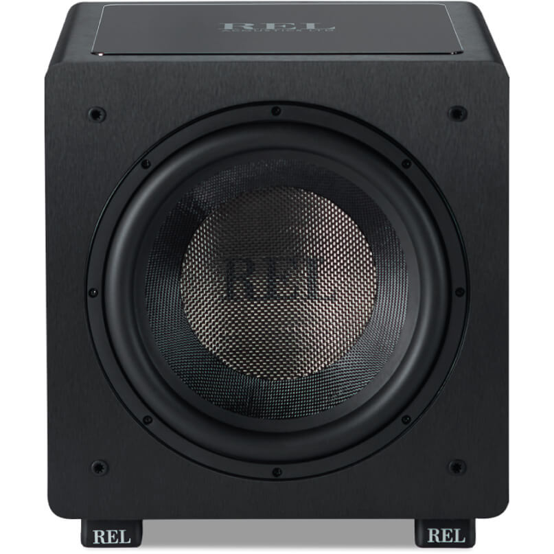 Rel Ht/1205 Rel subwoofer in black cabinet with large circular driver behind perforated mesh, chrome top plate, and rel branding on feet.