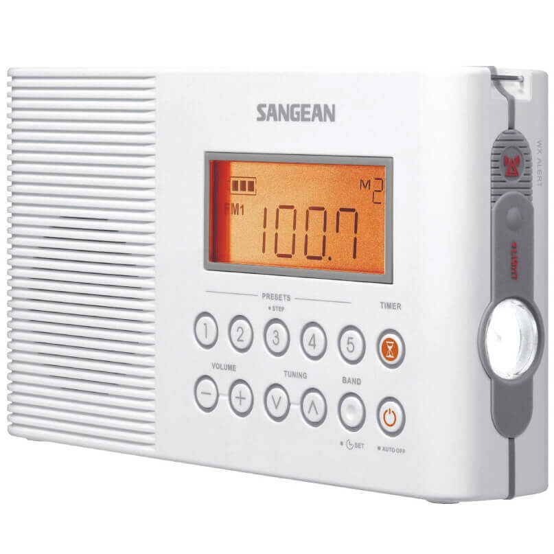 Sangean portable AM/FM digital radio with orange backlit display, white casing, preset buttons, and a side hand crank tuning dial.