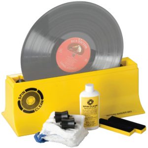 Interdyn Spin-clean record washer mkii cleaning system in yellow with vinyl record, washer fluid bottle, cloth, and brushes.