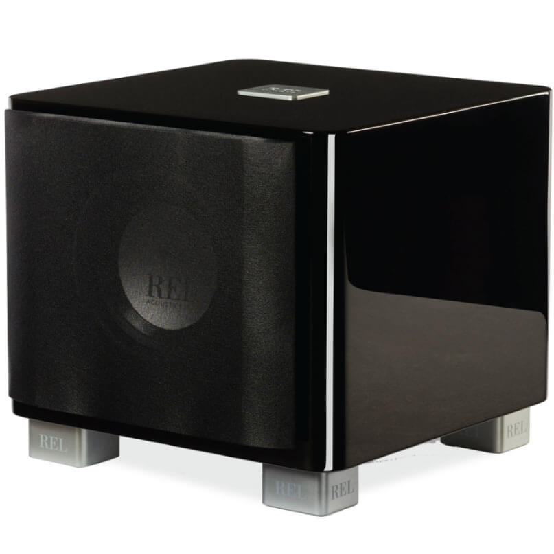 Rel Serie T/7X Rel subwoofer in a glossy black cube with fabric grille and silver feet.