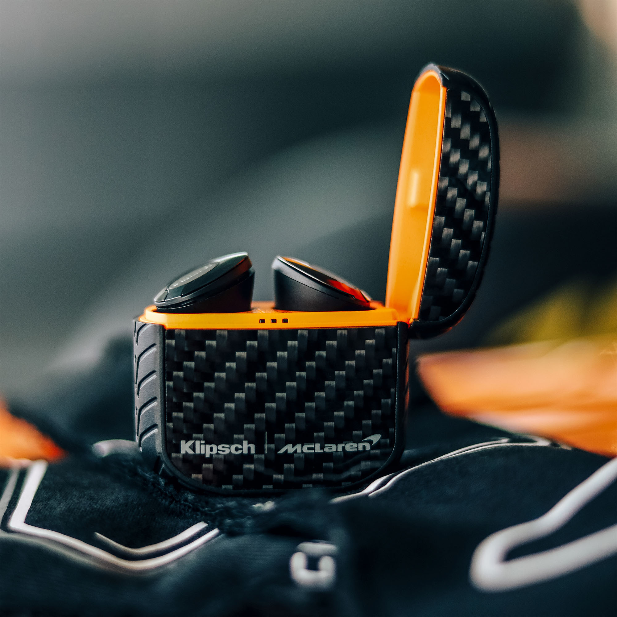 Klipsch Mclaren T5 Ii True Wireless Anc Earphones Close-up of klipsch mclaren headphones with carbon fiber headband and orange accent.