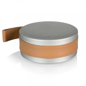 Round portable Bluetooth speaker with silver metal body, perforated top grille, and tan leather wrap strap.