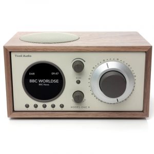 Wooden Tivoli Audio Model One+ tabletop radio with circular display, large silver dial, and multiple small control knobs.