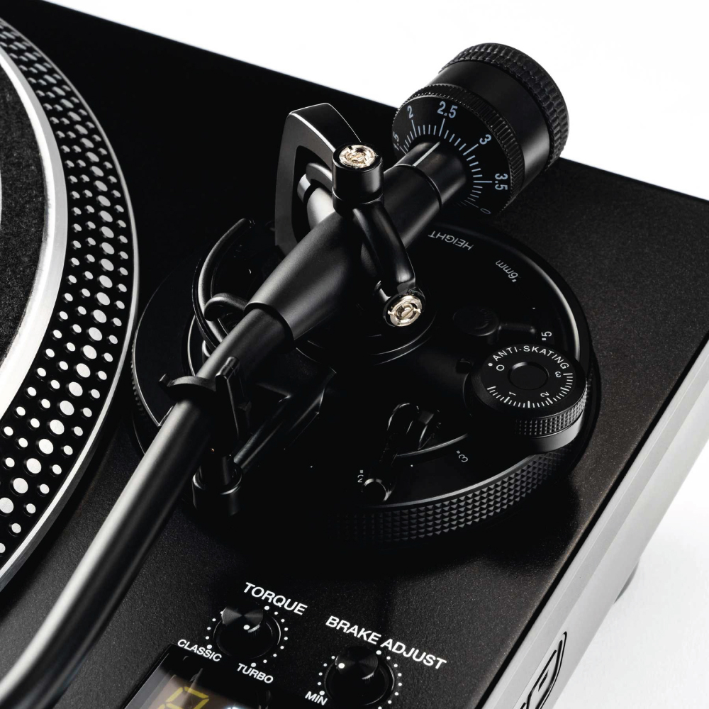 Reloop Rp-8000Mk2 Hybrid Direct Drive Dj Turntable Close up of a black dj turntable with tonearm, adjustable torque and brake controls, and anti-skating dial.