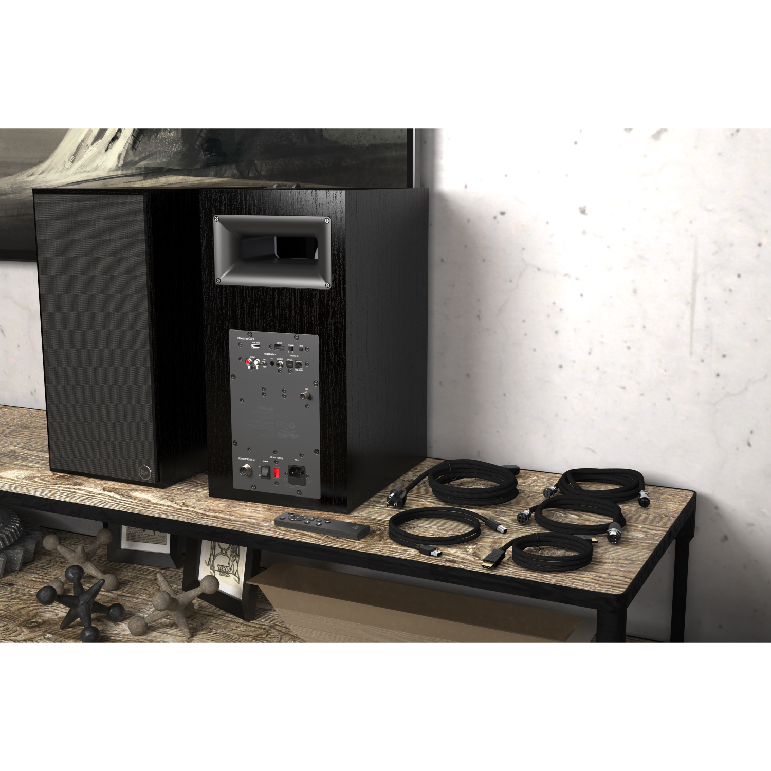 Klipsch The Nines Klipsch black wood-veneer floor-standing speaker system with a subwoofer, front grilles, rear input panel, and cables on a wooden table.