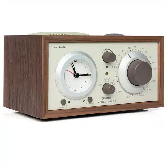 Tivoli Audio Model Three Bt Tivoli audio model three ii tabletop analog am/fm radio with wooden cabinet, clock face left, large tuning dial right.