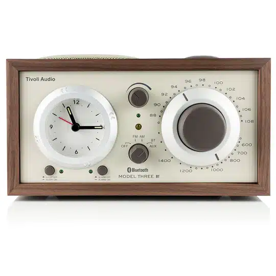 Tivoli Audio Model Three Bt Tivoli audio model three bt compact tabletop radio with white front, clock dial left, large tuning dial right, wood frame.