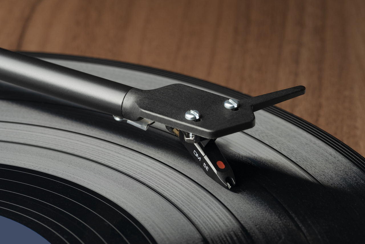Pro-Ject E1 Turntable With Ortofon Om 5E Cartridge Ortofon om 5e phono cartridge mounted on a tonearm over a vinyl record on a turntable
