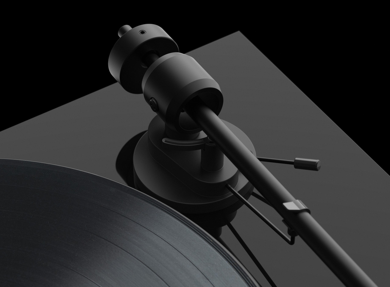 Pro-Ject E1 Turntable With Ortofon Om 5E Cartridge Black turntable with a diagonal tonearm and vinyl record on a dark reflective surface.