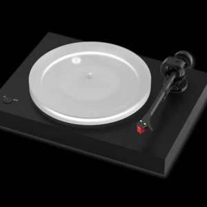 Turntable with a white platter on a black base and a tonearm with a red cartridge.