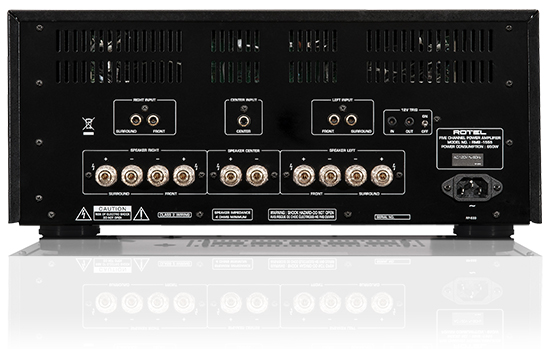 Rotel Rmb-1555 Multi-Channel Power Amplifier Rear panel of a rotel power amplifier with multiple speaker terminals, rca connectors, ventilation slots, and iec power input.