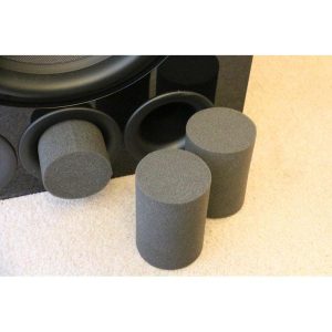 Interdyn Black foam speaker isolation cylinders placed on carpet beside a large black speaker.