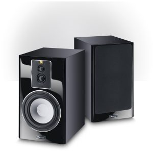 Magnat bookshelf speakers with glossy black fronts; left unit shows dual drivers midrange and woofer, right unit has fabric grille.
