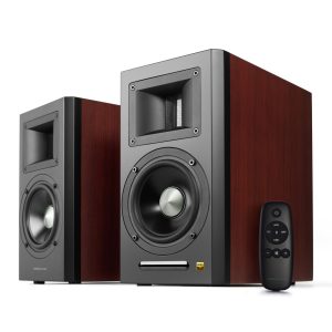 Hi-fi stereo speaker set with two wood-veneer cabinets, large woofer drivers and rectangular midrange ports, accompanied by a black remote.