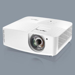 White multimedia projector with a large front lens, top control panel, and side ventilation.