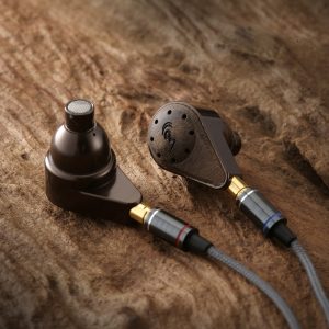 Brown in-ear monitor earphones with perforated metal faceplates and detachable braided cables.