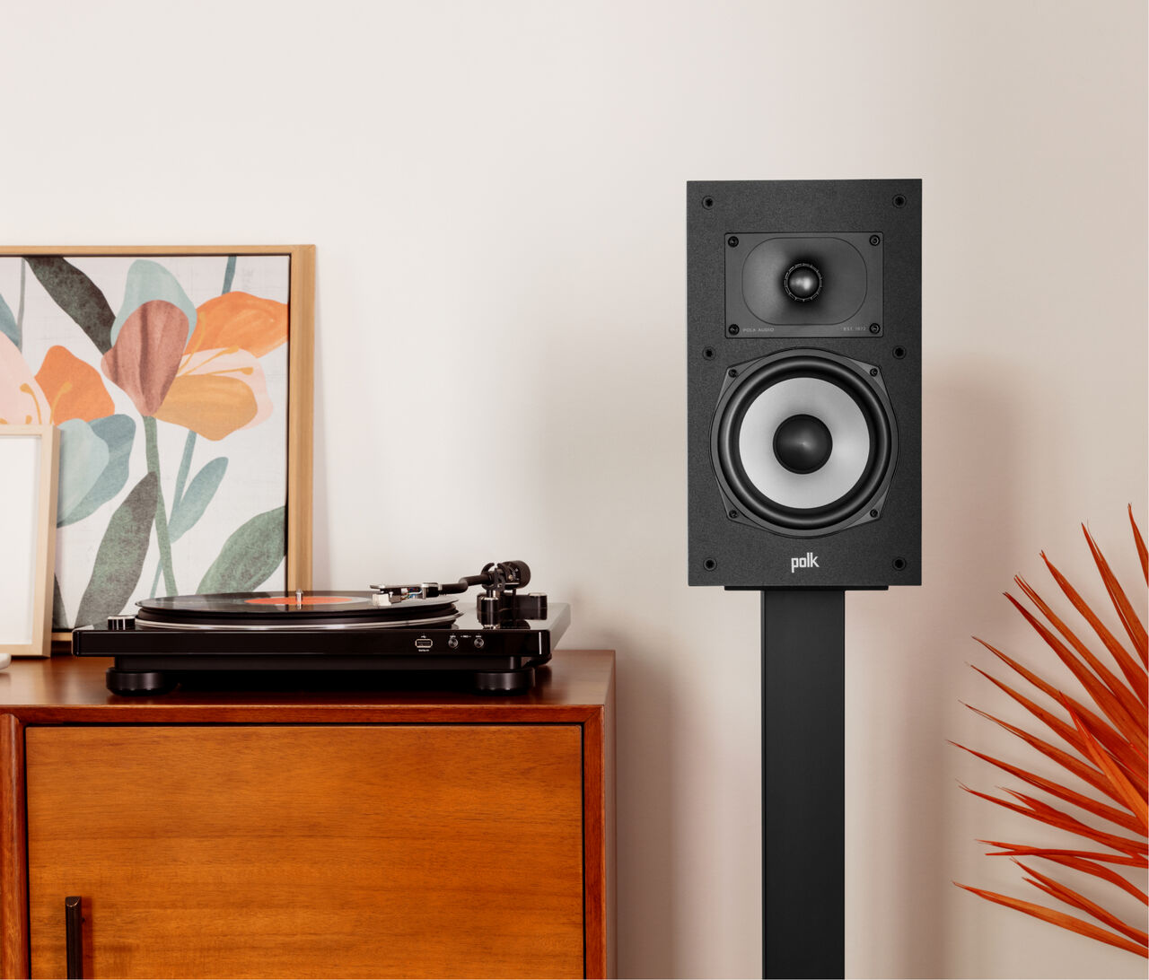 Polk Monitor Xt20 Polk audio bookshelf speaker on a black floor stand, with a white-cone woofer and small tweeter.