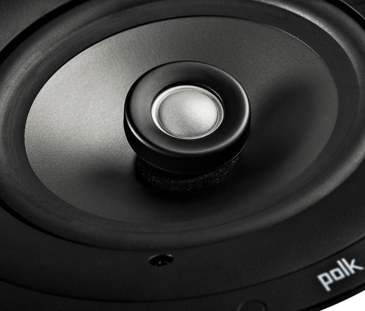 Polk V60 Slim Polk audio loudspeaker driver with black woofer cone and silver dust cap in the center.