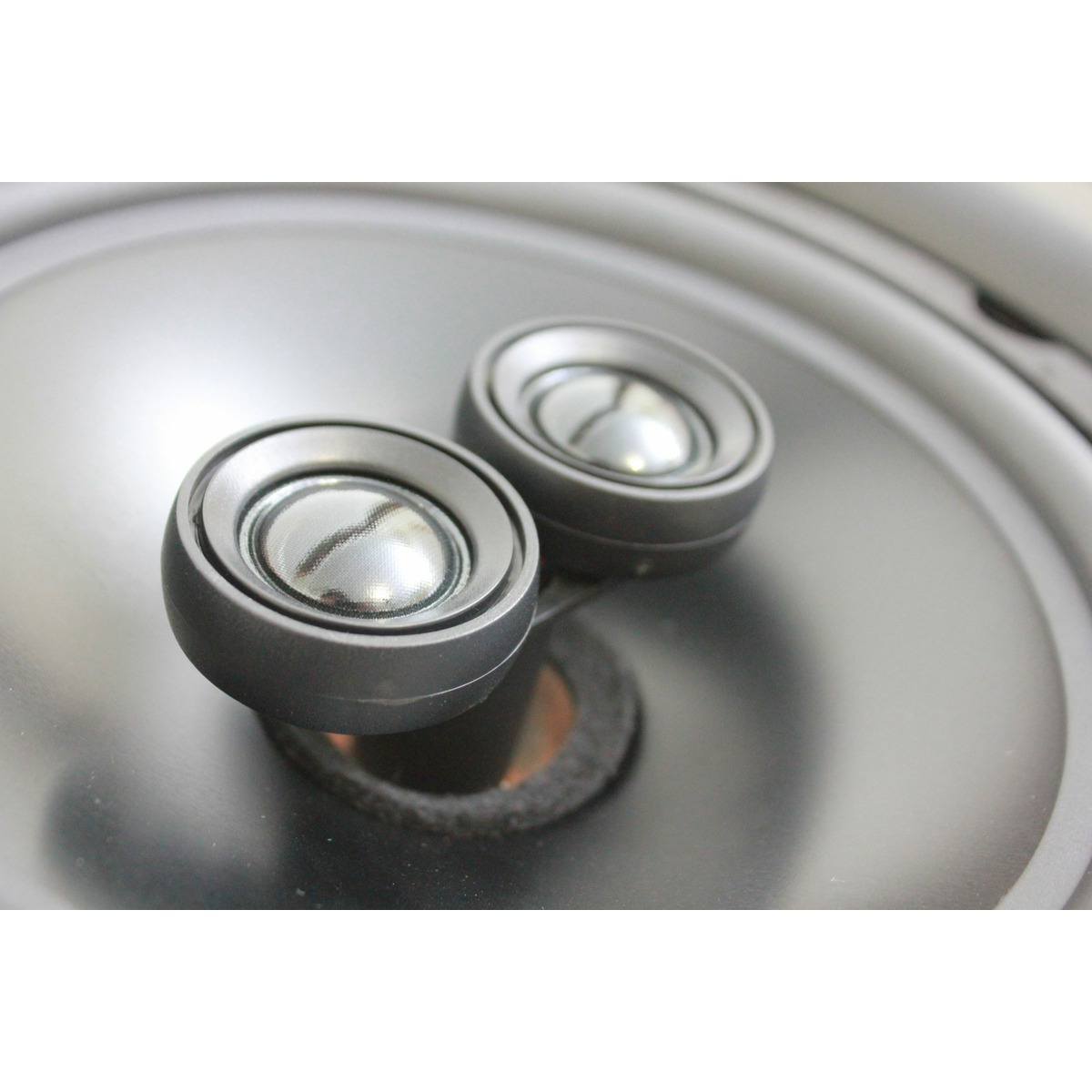 Xcelsus Audio Xic820 Pair of small black camera lenses with glass fronts mounted on a curved dark surface.
