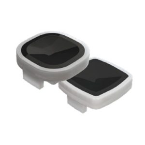 Pair of white plastic electronic devices with glossy black surfaces, circular and rectangular, connected by a small white base.