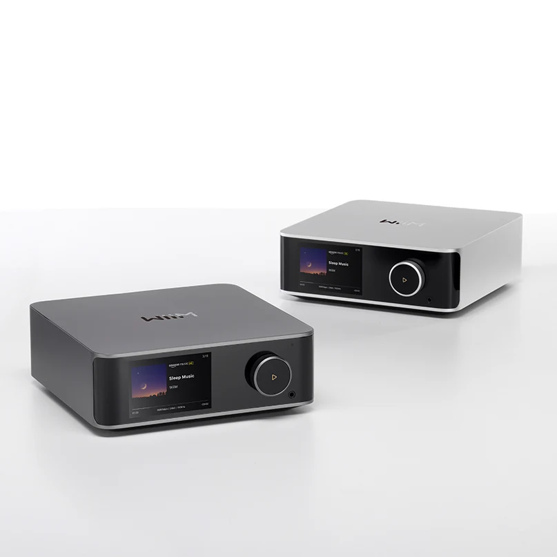 Wiim Ultra Wireless Audio Streamer And Digital Hub Two compact desktop digital music players with color screens and large round volume knobs.
