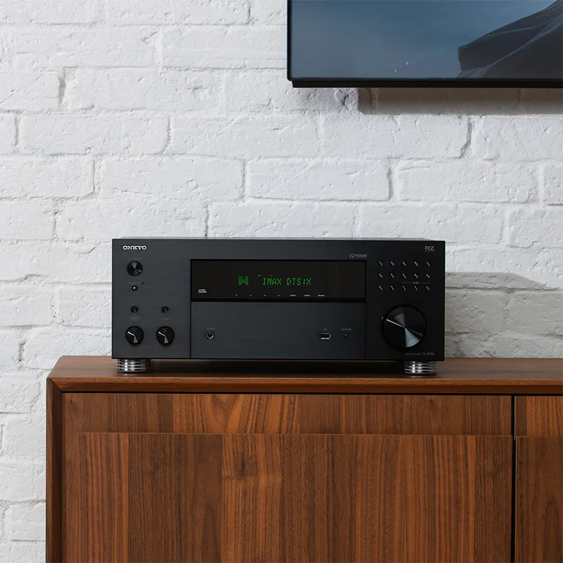 Onkyo Tx-Rz30 Av Receiver Onkyo rz-series av receiver in black metal casing with a green display showing imax dts:x, on a wooden cabinet.