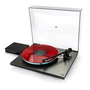 REGA Planar 3 RS Turntable Modern turntable with a clear dust cover, black base, red translucent vinyl on a metal platter, and tonearm with cartridge.