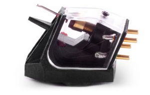 Phono cartridge with transparent housing and four gold connector pins mounted on a black base.
