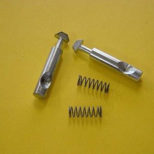 Two steel spring plungers with square heads and two coil springs on a yellow background.