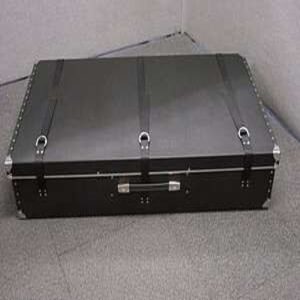 Black metal flight case with riveted edges, three latching clasps, and a sturdy front handle.