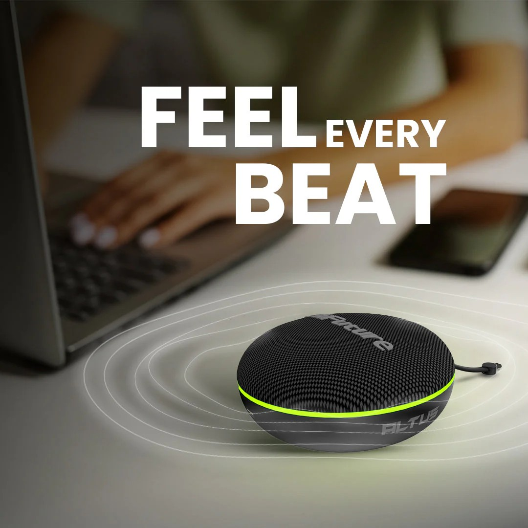 Hifuture Altus Portable Bluetooth Speaker - Black Round black fabric bluetooth speaker with neon green edge on a desk, with a laptop and smartphone in the background.