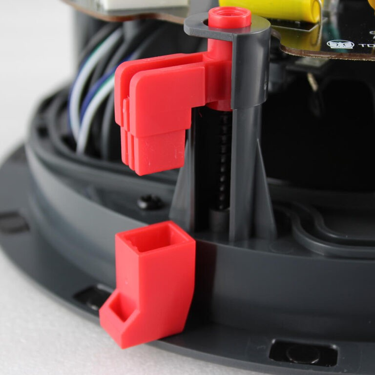 Tdg Audio Architectural 8&Quot; Ceiling Speakers Close-up of red plastic latch and square connector in a dark electronic base with visible wiring.