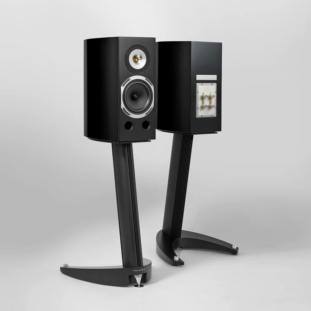 Triangle Magellan Duetto 40Th Premium Bookshelf Speaker Pair of black triangle stand-mounted bookshelf speakers on curved floor stands, front woofer and tweeter visible with ports.