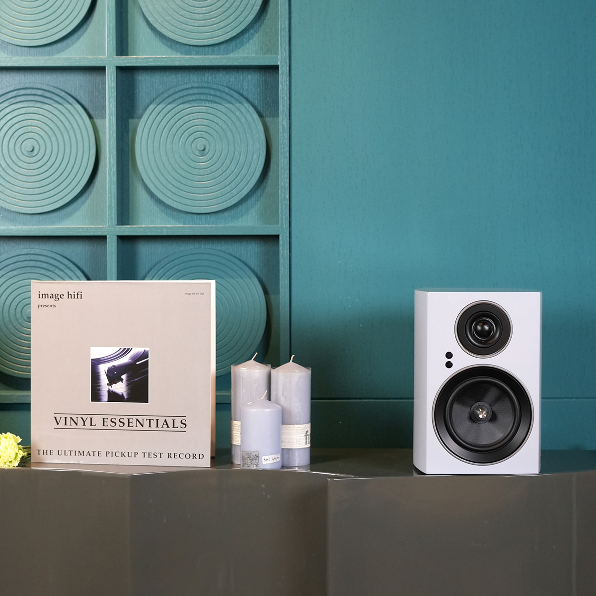 Jamo C707 Pa Active Bookshelf Speaker White bookshelf speaker beside vinyl essentials record cover.